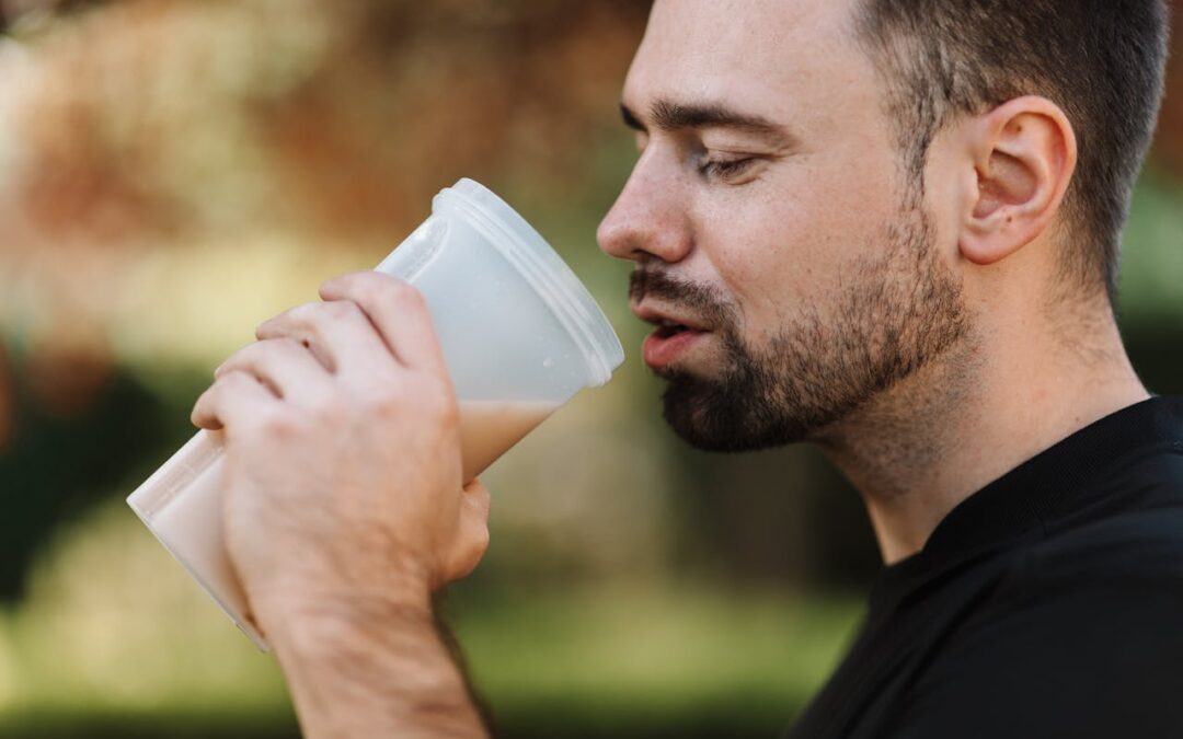 Hombre deportista bebiendo batido de proteínas